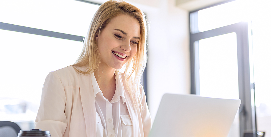 Une femme travaille sur un ordinateur portable en utilisant les plates-formes de gestion de Bell.