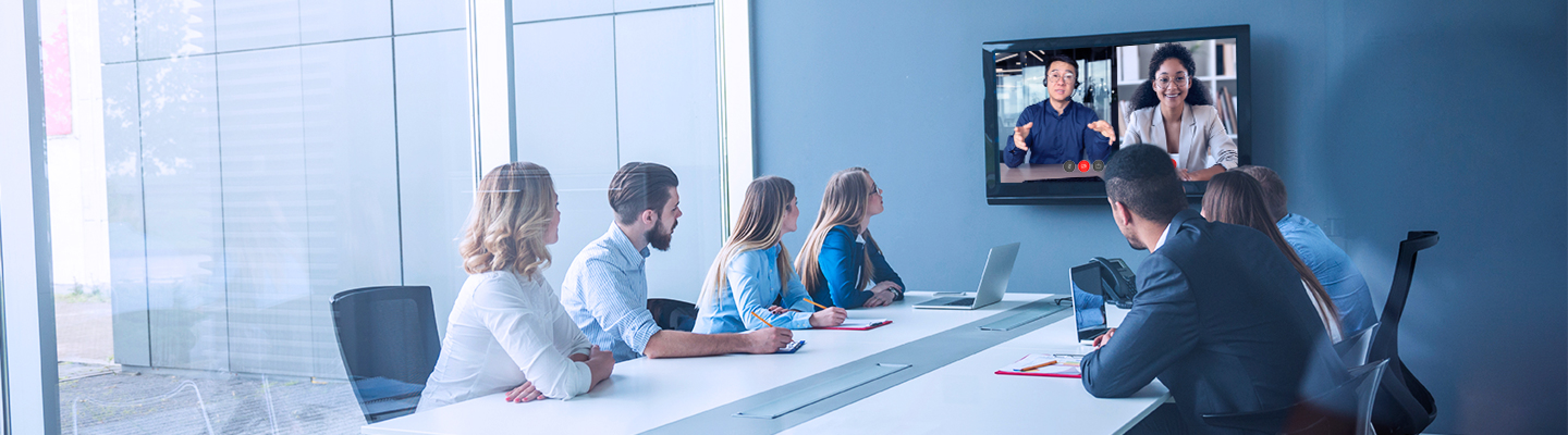 Colleagues in an office maintaining productivity by connecting with remote workers on a video call using a voice and collaboration solution from Bell.