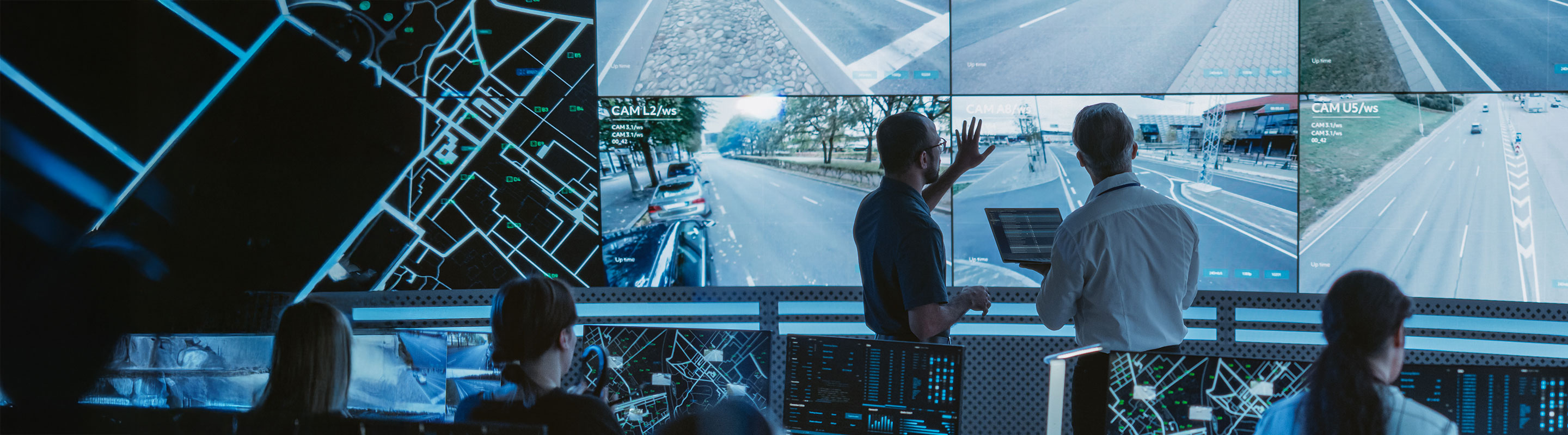 Dans un centre de contrôle, deux experts analysent des données en temps réel sur des écrans numériques grâce à une infrastructure intelligente alimentée par des réseaux de connectivité IdO évolués.
