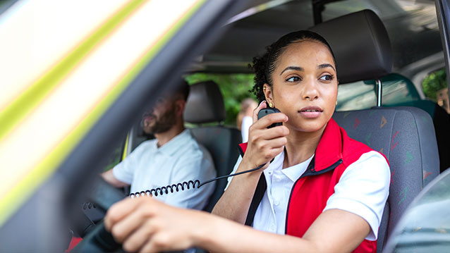 Intervenant de premier recours utilisant un appareil de communication fiable dans un véhicule, démontrant l'infrastructure essentielle de Bell pour la sécurité publique.