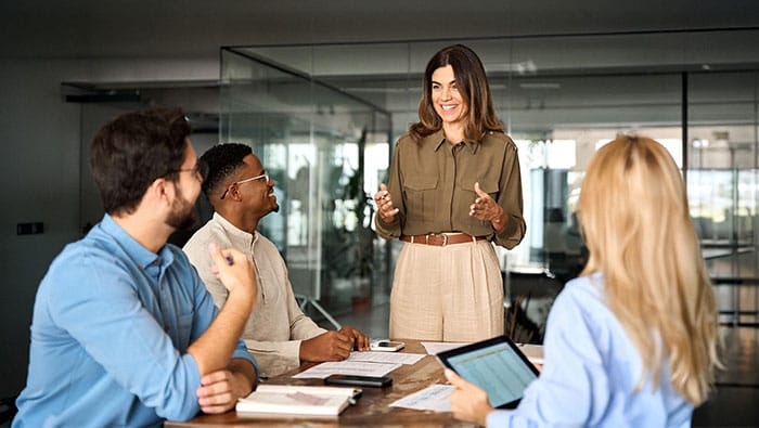 Une équipe diversifiée d'experts en IdO collabore autour d'une table de conférence dans un bureau moderne.