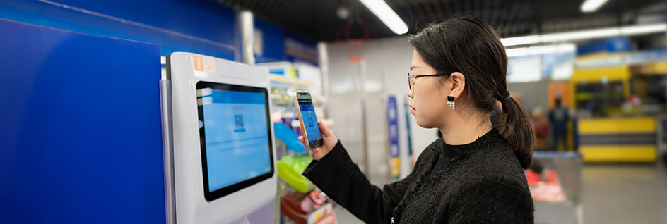 A shopper uses the CPROMO phone app to scan a QR code which will allow her to obtain her complimentary bags from the dispensing machines.