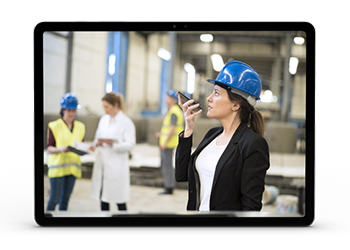 Woman in a factory talking with employees in the field on the latest Push-to-talk supported device.